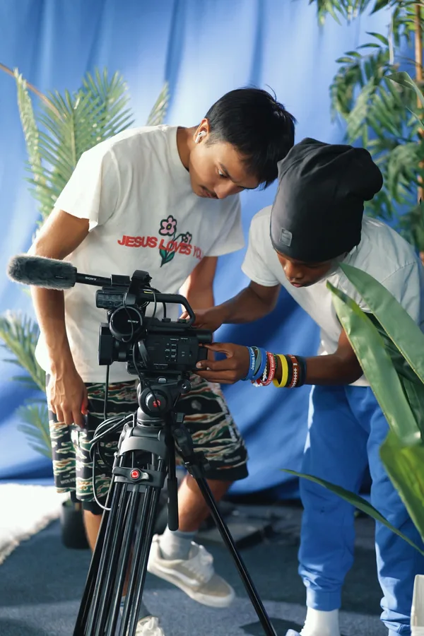 Two camera operators preparing a professional video camera